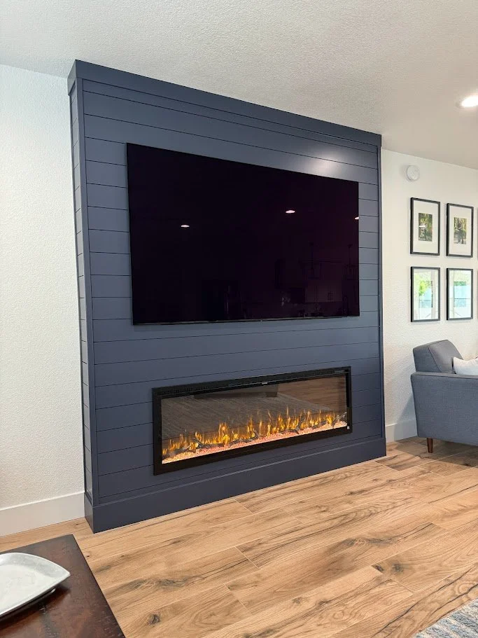 Fireplace media wall negra terminada con TV, chimenea y mantel