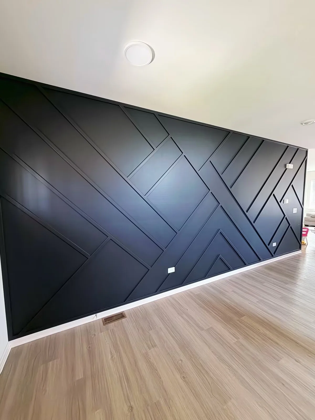 Pared geométrica negra de gran formato terminada por Elite Accent Wall